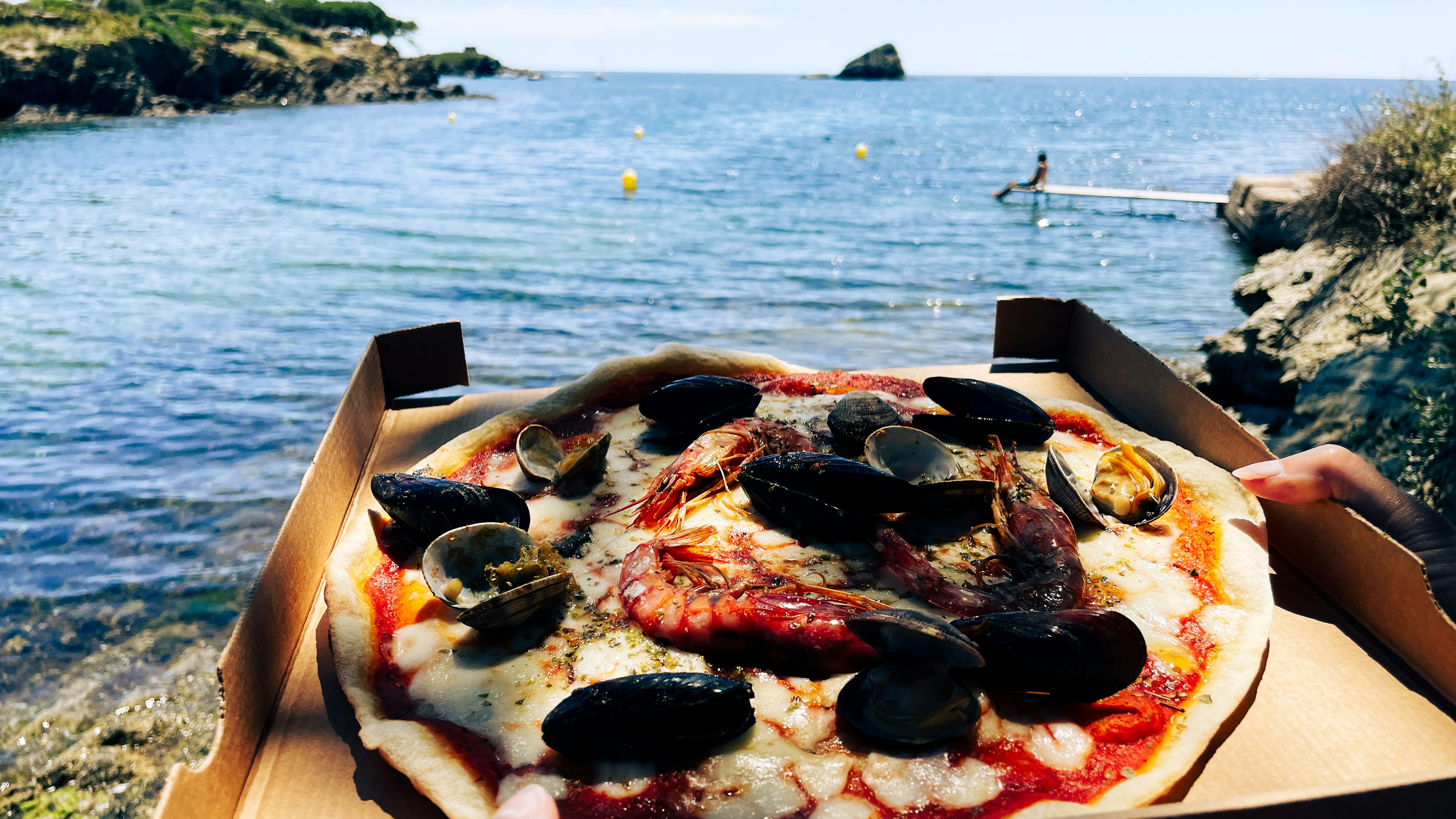 Meeresfrüchte Pizza in Karton am Meer