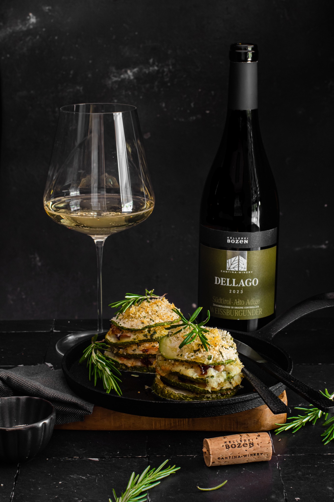 Flasche Dellago und Weißweinglas neben vegetarischem Gericht