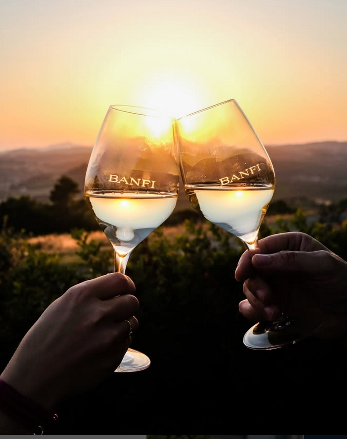 2 Gläser mit Banfi Gravur st0ßen vor Sonnenuntergang an