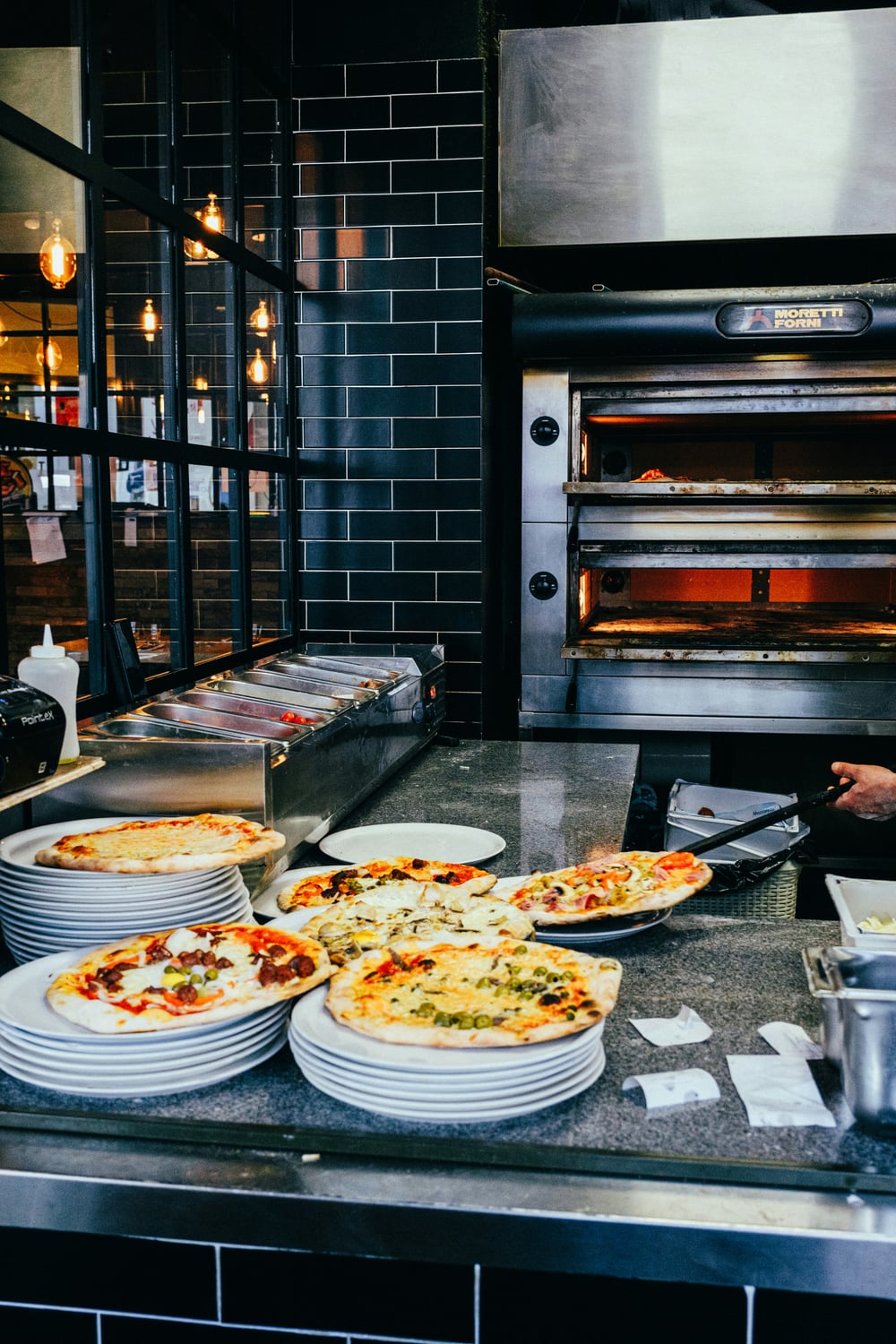 Teller auf Theke vor Pizzaofen
