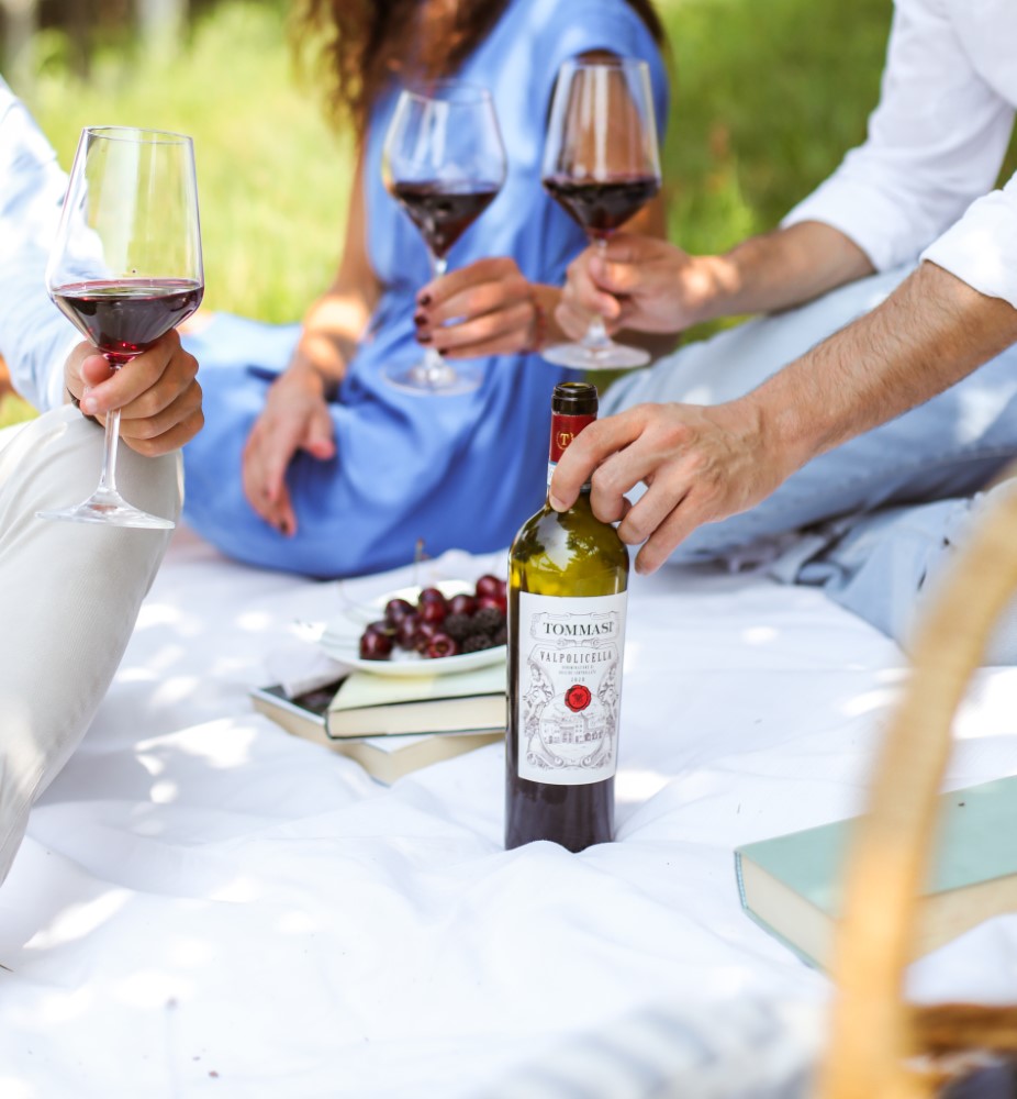 Picknickszene mit 3 Personen die Tommasi Valpolicella trinken